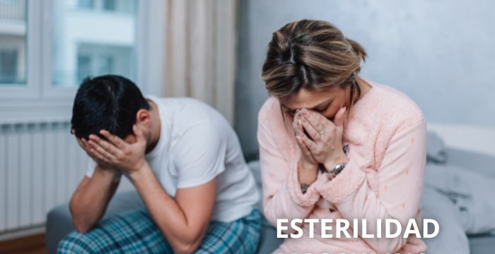 Pareja de hombre y mujer, sentados en la cama con las manos en la cara